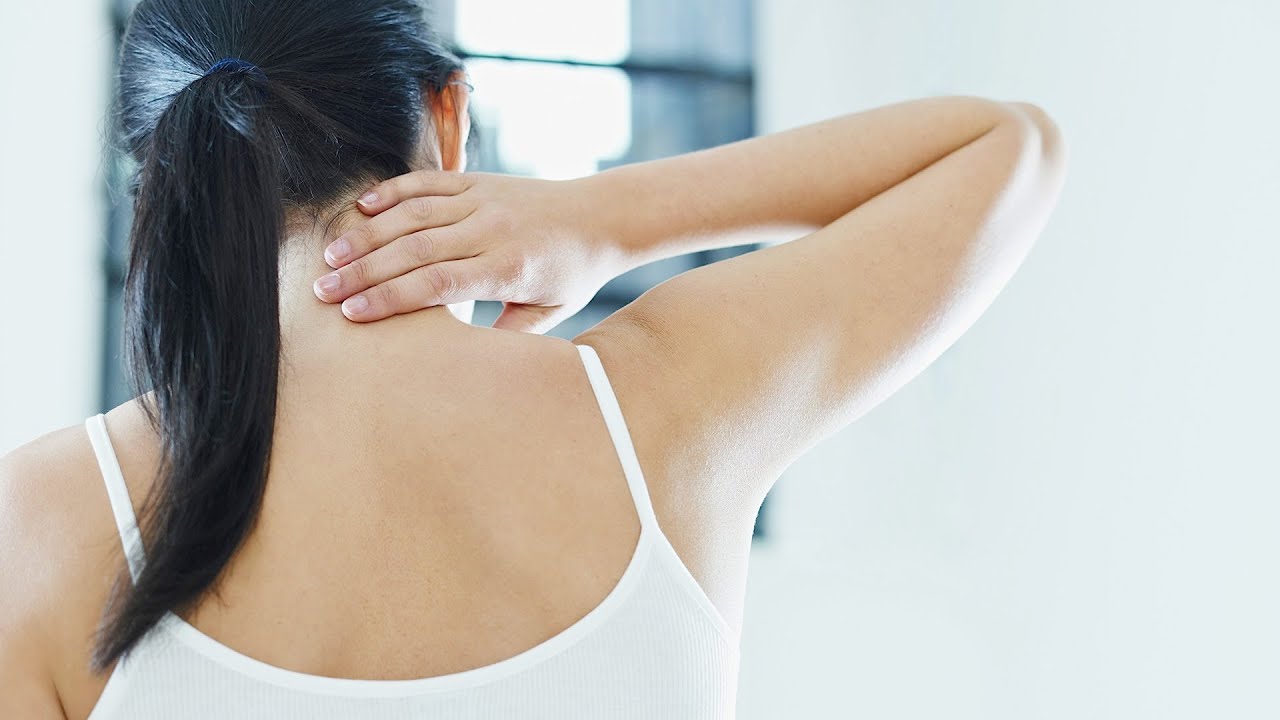 woman touching her neck
